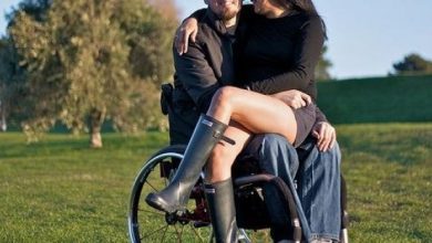 Woman sat in the lap of a man in a wheelchair