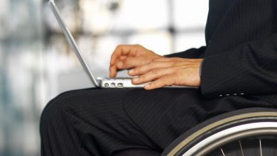 Businessman sitting in a wheelchair working in a laptop