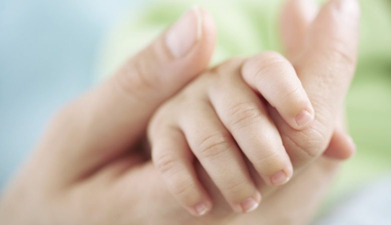 Mum holding a baby hand