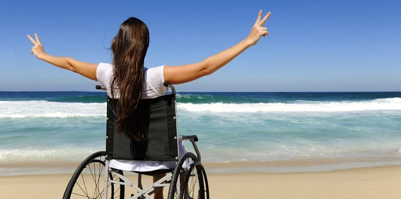 Disabled woman in wheelchair on beach