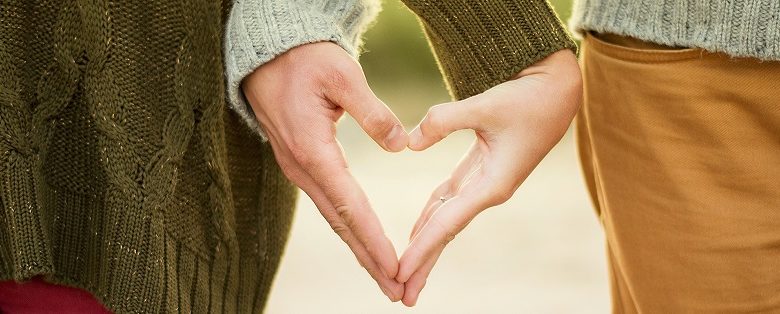 Couple making a heart shape with their hands