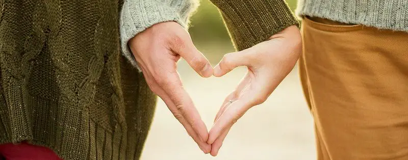 Couple making a heart shape with their hands