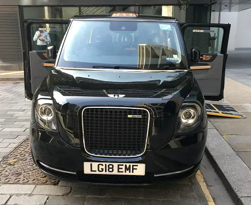 Accessible black cab with doors open and ramp out