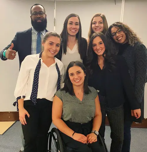 Trainee audiologist Oliva in a wheelchair with her colleagues