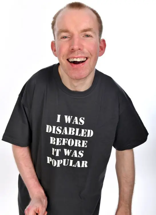 Lost Voice Guy Lee Ridley in a TV shirt saying I was disabled before it was popular