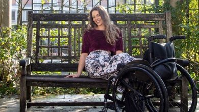 Disabled model Samanta Bullock sat on a bench with legs resting on wheelchair