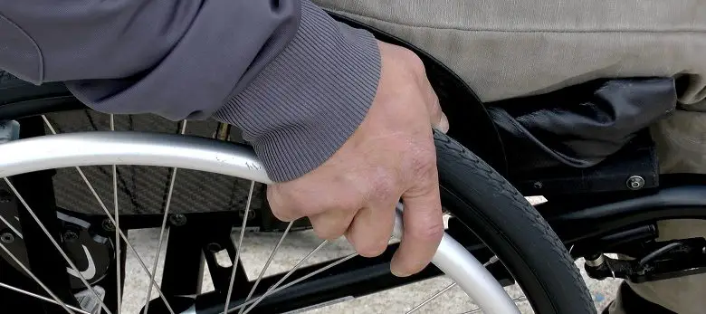 Disabled man's hand on his wheelchair wheel