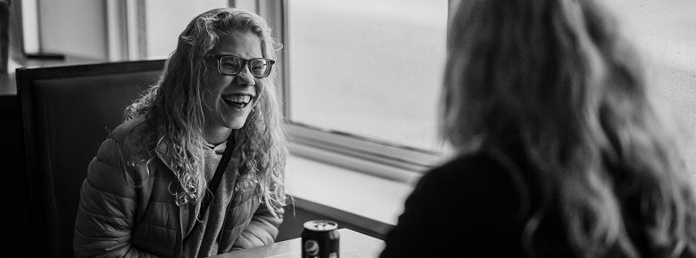 Disabled woman with personal care assistant in coffee shop