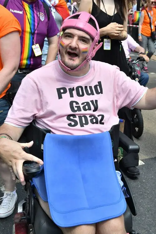 Disabled-activist-Simon-Stevens-at-Gay-Pride-in-a-pink-t-shirt-with-the-words-Proud-gay-spaz-500x750.jpg