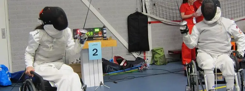 Two people wheelchair fencing