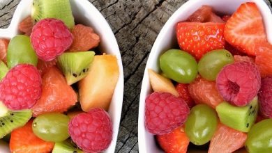 Mixed fruit in two heart-shaped dishes on a wooden table