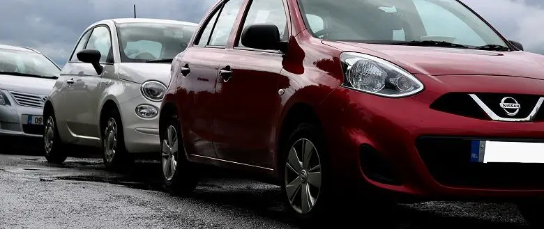 Three cars parked at the side of a road