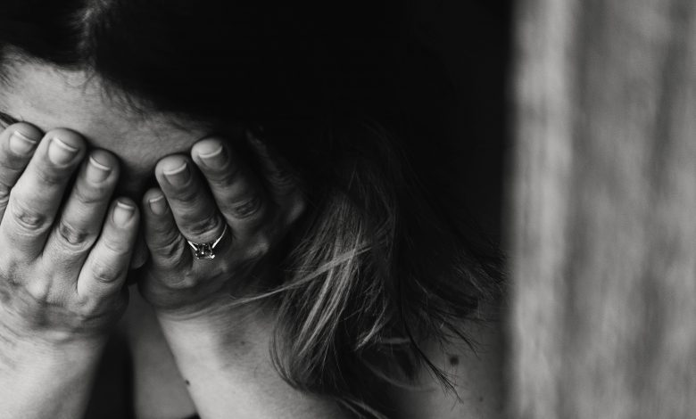 Black and white image of woman with her head in her hands