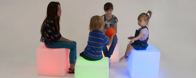 Children with autism playing with a sensory ball sat in a circle