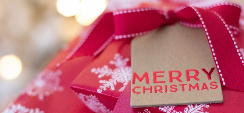 Christmas presents in red wrapping paper with snowflakes and a tag saying Merry Christmas