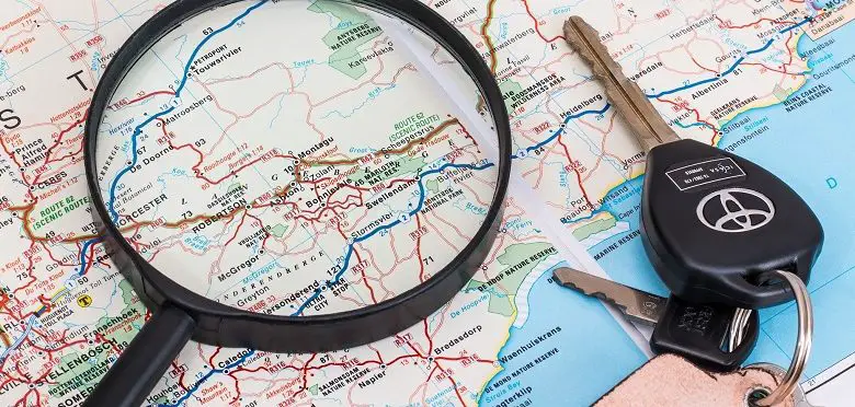 Map with magnifying glass and car keys on top