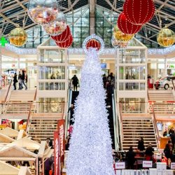 Christmas shopping centre with white Christmas tree and baubles hanging from the ceiling