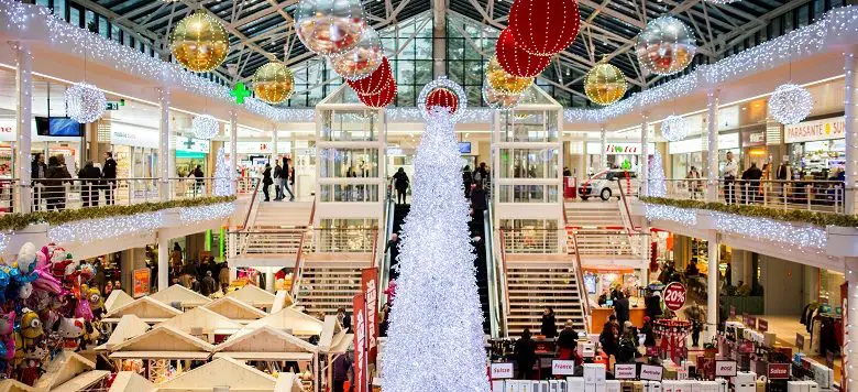 Christmas shopping centre with white Christmas tree and baubles hanging from the ceiling