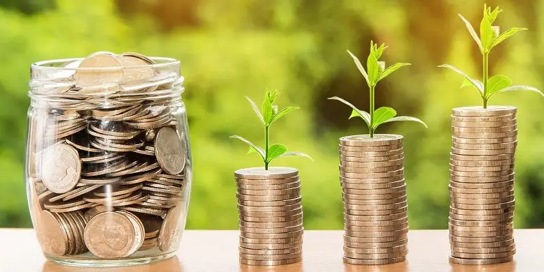 Piles of money with plants growning out of them and a jar of coins