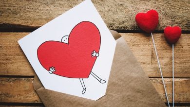 Valentine's Day card one a wooden table with illustration of man holding a red heart