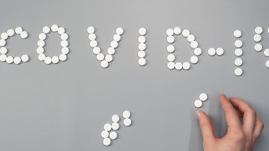 Covid-19 spelt out in pills on a grey background