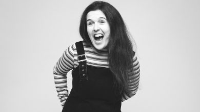 Black and white image of disabled comedian Rosie Jones smiling