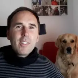 Martyn Sibley with his dog Sunny on a chair behind him