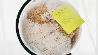 World globe with a post it note saying 'stay home'