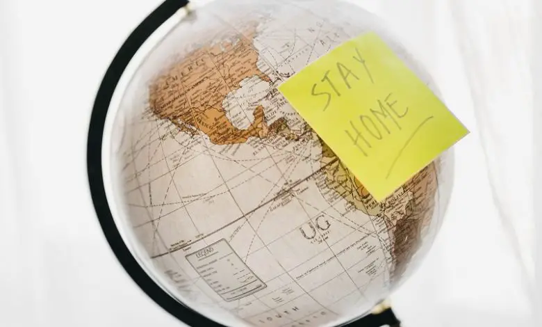 World globe with a post it note saying 'stay home'