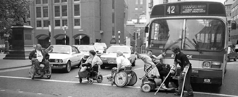 Black and white image from the 60s of disaled people blocking a road