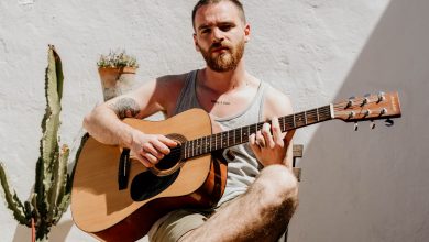 Man playing acoustic guitar Credit and/