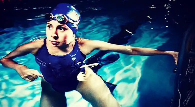 Liz Johnson in a blue swimming costume and hat in a swimming pool