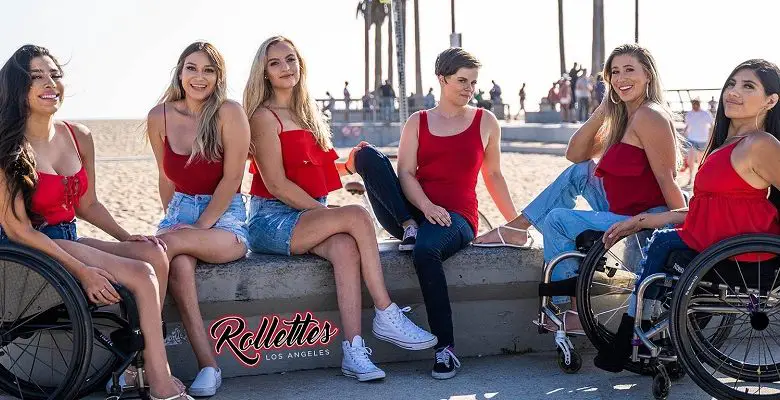 Rollettes possed in front of a beach all wearing red tops