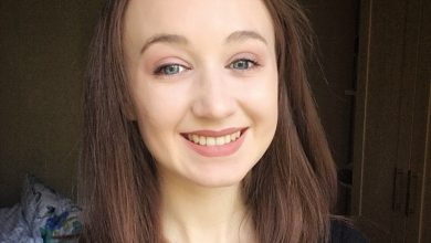 Close up of Pippa wearing a black top with brown hair and natural make up