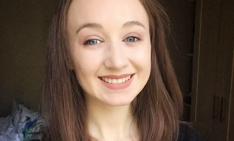 Close up of Pippa wearing a black top with brown hair and natural make up