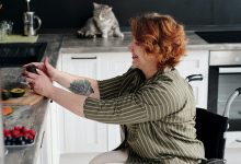 Woman in a wheelchair preparing food on the worktop in a kitchen