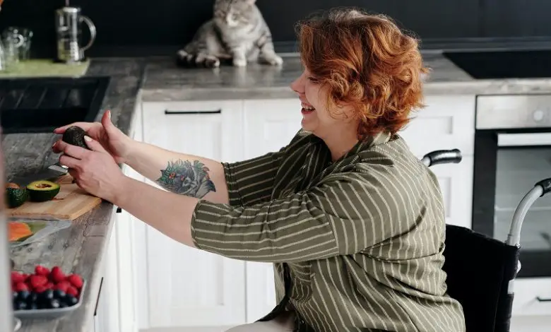 Woman in a wheelchair preparing food on the worktop in a kitchen