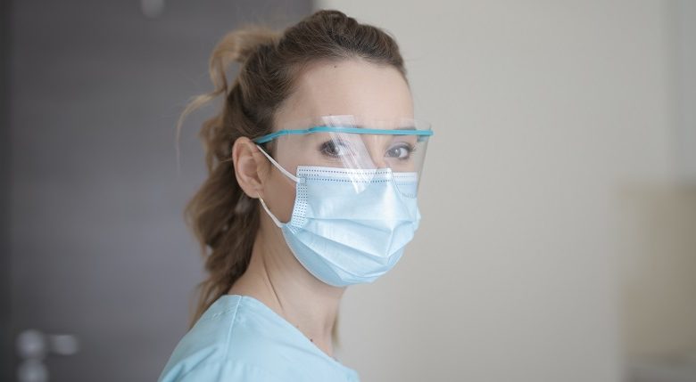 Woman wearing a surgical mask and eye protection