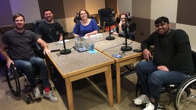 Ruth sat around a table with her fellow podcast makers recording an episode of This is Spinal Crap