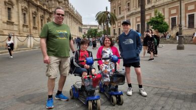 Emma with her two sons and husband in a market square between ornate buildings