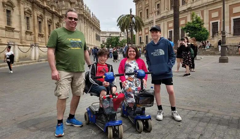 Emma with her two sons and husband in a market square between ornate buildings
