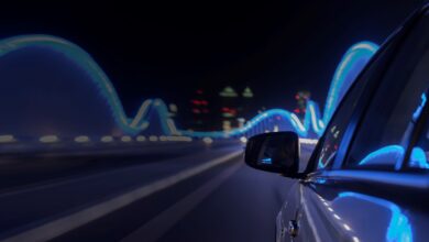 Side of a car driving at night with lights reflected on it