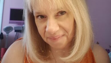 Disabled gardener Nikki Preston close up with blonde hair and wearing an orange top off the shoulders