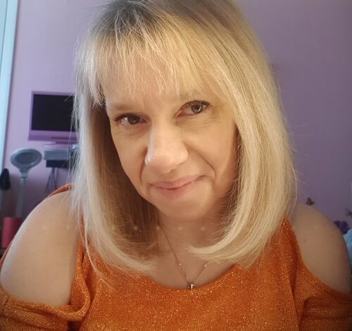 Disabled gardener Nikki Preston close up with blonde hair and wearing an orange top off the shoulders