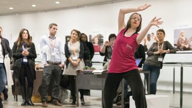 Jan in a pink top dancing in front of a group of people