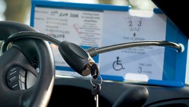 The Blue Badge Protector anti-theft device being used in a car around a steering wheel and Blue Badge Holder