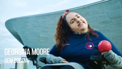 Georgina Moore holding red boccia ball outside of olympic venue