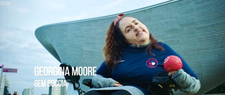 Georgina Moore holding red boccia ball outside of olympic venue