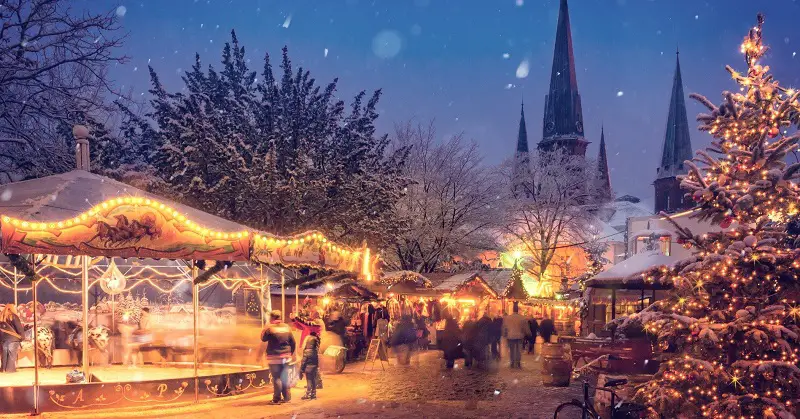 Christmas market at dusk covered in snow