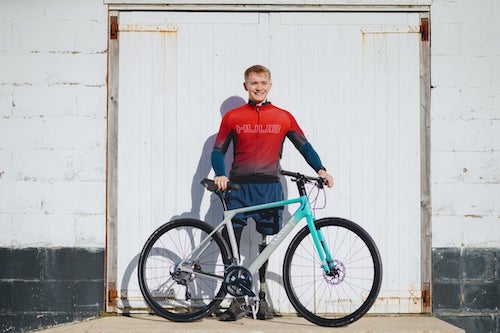 Billy Monger standing with his bike